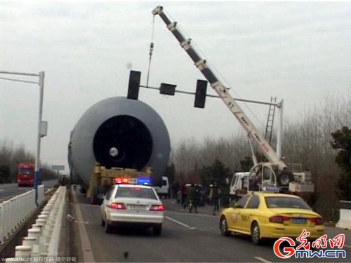 南京：百吨“庞然大物”通行难 一路拆信号灯警车护航